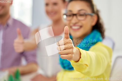 Image of happy young woman showing thumbs up