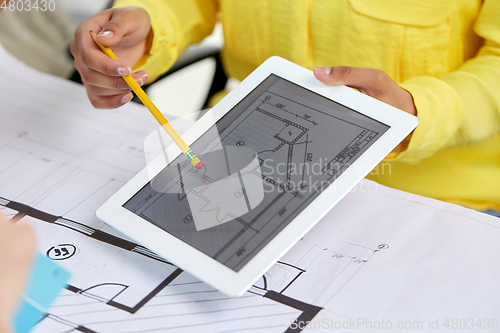 Image of close up of architects with blueprint on tablet pc