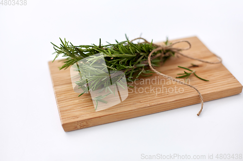 Image of bunch of rosemary on wooden cutting board