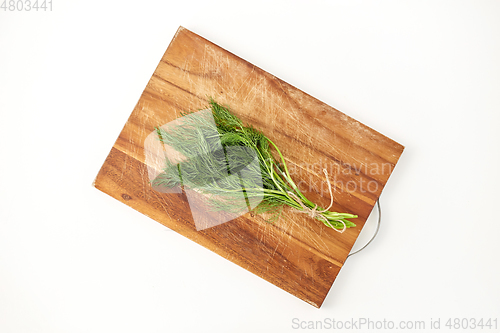 Image of bunch of dill on wooden cutting board