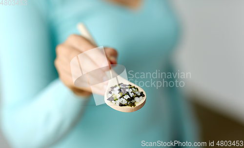 Image of close up of woman with sea salt on wooden spoon