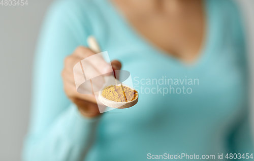 Image of close up of woman with curry on wooden spoon