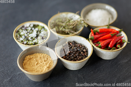 Image of bowls with different spices on slate stone table