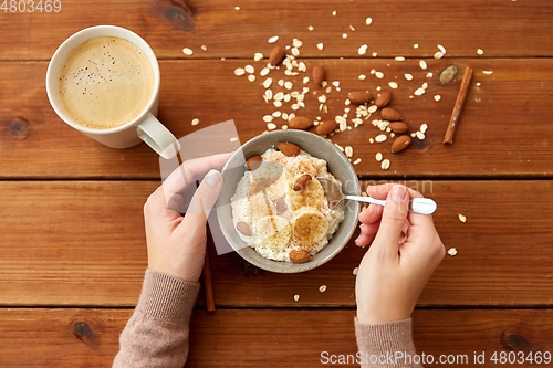 Image of hands with oatmeal breakfast and cup of coffee