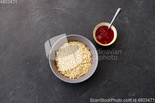 Image of oatmeal breakfast and cup of fruit jam with spoon