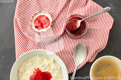 Image of porridge breakfast with jam, spoon and coffee