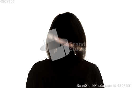 Image of Dramatic portrait of a girl in the dark on white studio background.