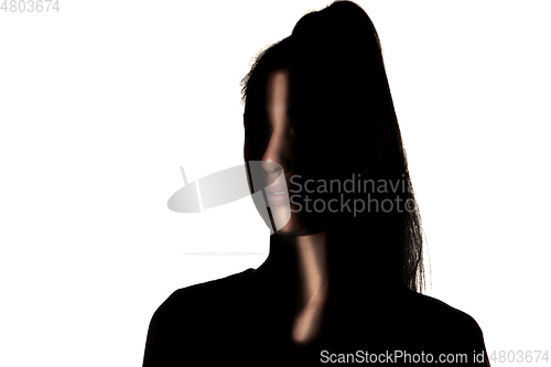 Image of Dramatic portrait of a girl in the dark on white studio background.