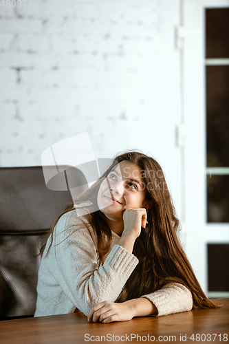 Image of Portrait of young caucasian girl in casual clothes looks dreamful and happy