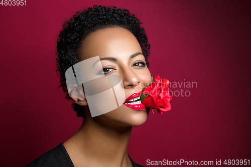 Image of beautiful woman with rose in mouth