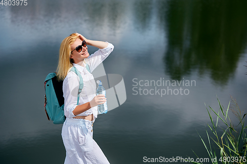 Image of Young woman resting near lake