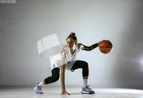 Image of Young caucasian female basketball player against white wall background
