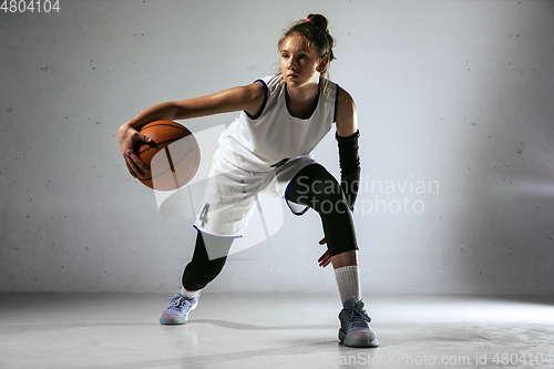 Image of Young caucasian female basketball player against white wall background