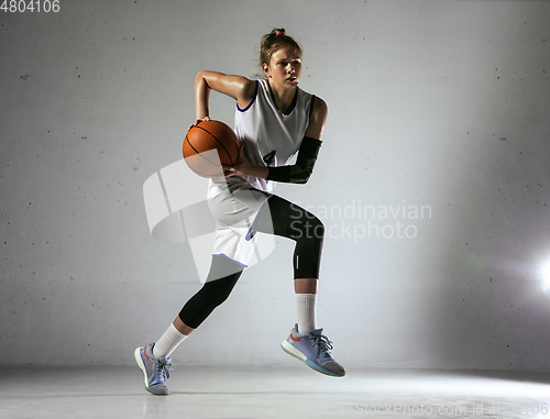 Image of Young caucasian female basketball player against white wall background