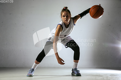 Image of Young caucasian female basketball player against white wall background