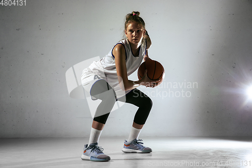 Image of Young caucasian female basketball player against white wall background