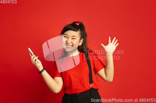 Image of Asian teenager\'s portrait isolated on red studio background