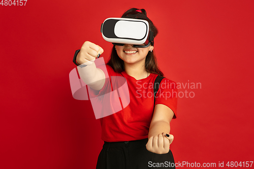 Image of Asian teenager\'s portrait isolated on red studio background