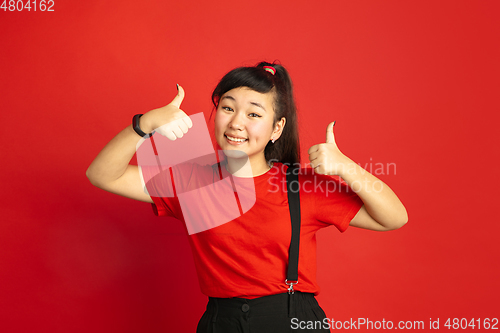 Image of Asian teenager\'s portrait isolated on red studio background