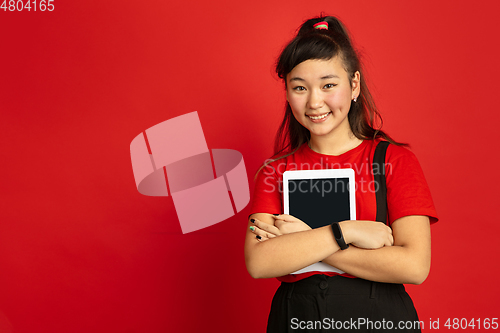 Image of Asian teenager\'s portrait isolated on red studio background