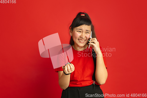 Image of Asian teenager\'s portrait isolated on red studio background