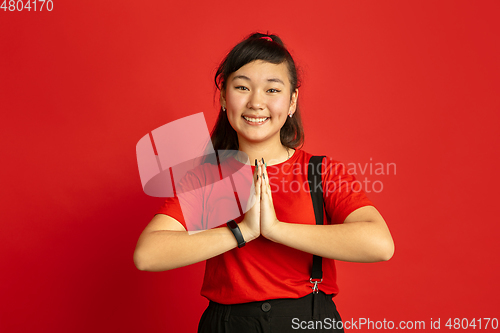 Image of Asian teenager\'s portrait isolated on red studio background