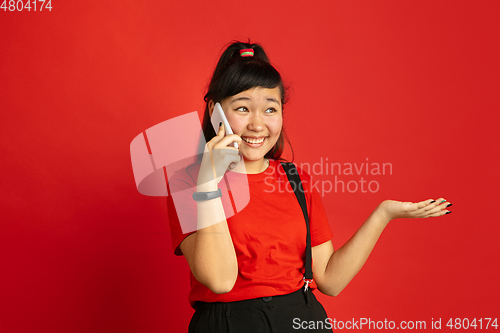 Image of Asian teenager\'s portrait isolated on red studio background