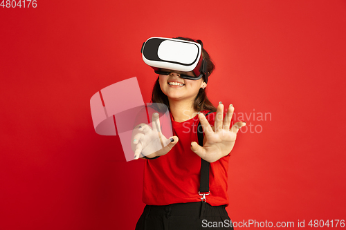 Image of Asian teenager\'s portrait isolated on red studio background