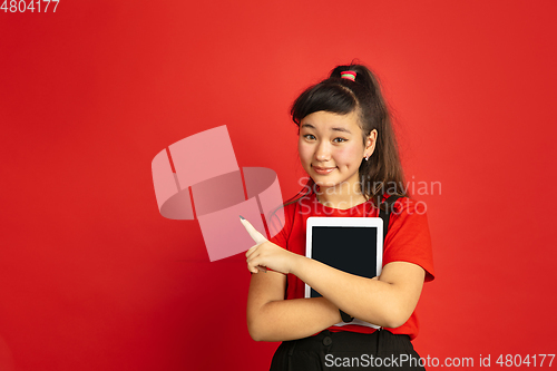 Image of Asian teenager\'s portrait isolated on red studio background