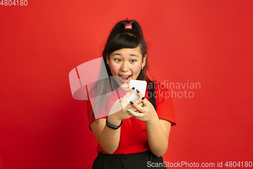 Image of Asian teenager\'s portrait isolated on red studio background
