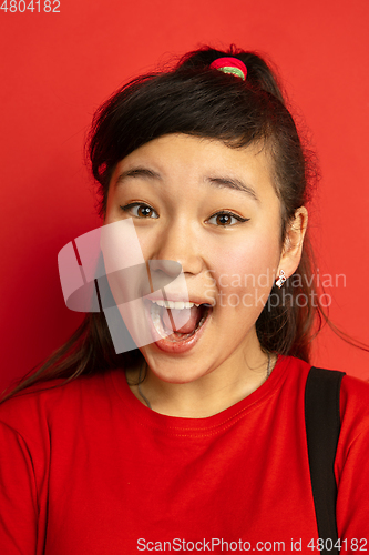 Image of Asian teenager\'s close up portrait isolated on red studio background