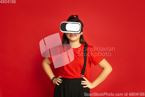 Image of Asian teenager\'s portrait isolated on red studio background