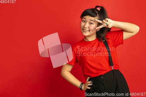 Image of Asian teenager\'s portrait isolated on red studio background