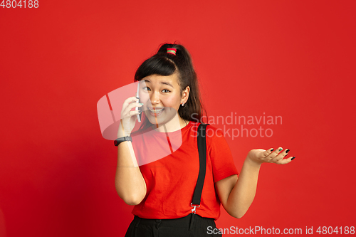 Image of Asian teenager\'s portrait isolated on red studio background