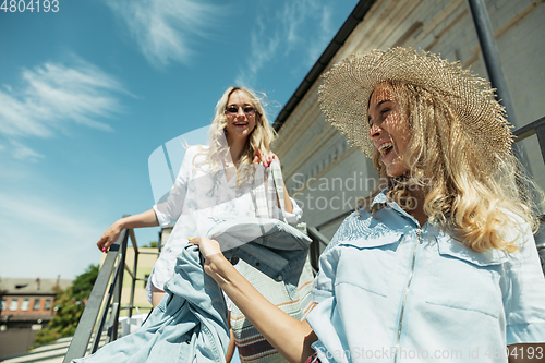 Image of Young lesbian\'s couple preparing for vacation trip on the car in sunny day