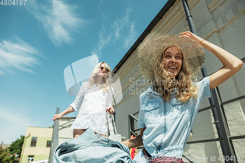 Image of Young lesbian\'s couple preparing for vacation trip on the car in sunny day