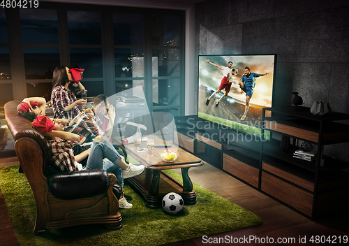 Image of Group of friends watching TV, football match, sport together