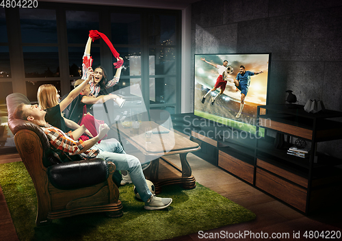 Image of Group of friends watching TV, football match, sport together