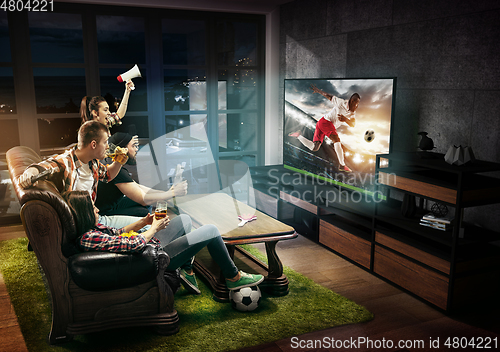 Image of Group of friends watching TV, football match, sport together