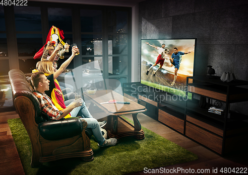 Image of Group of friends watching TV, football match, sport together