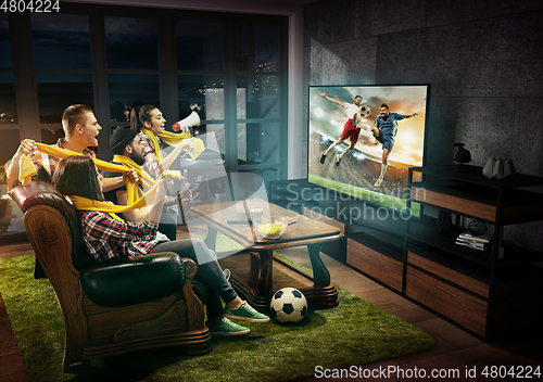 Image of Group of friends watching TV, football match, sport together