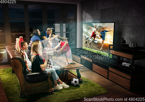 Image of Group of friends watching TV, football match, sport together