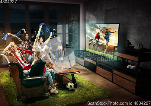 Image of Group of friends watching TV, football match, sport together