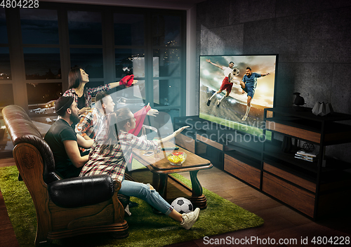 Image of Group of friends watching TV, football match, sport together