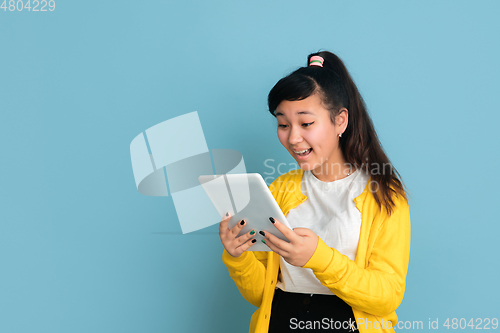 Image of Asian teenager\'s portrait isolated on blue studio background