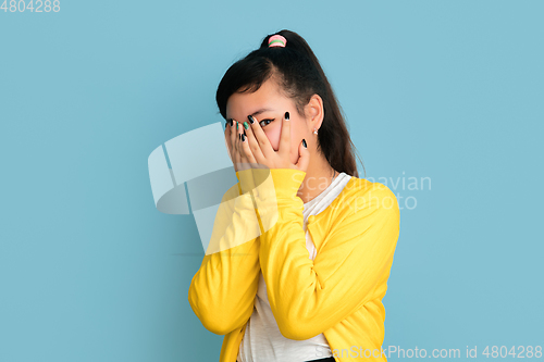Image of Asian teenager\'s portrait isolated on blue studio background