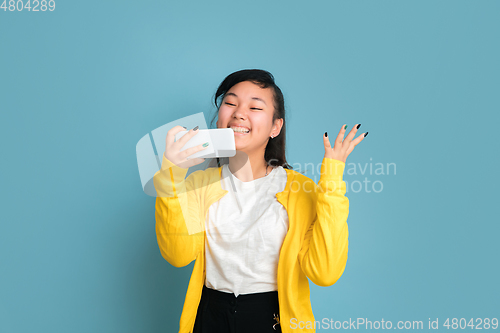 Image of Asian teenager\'s portrait isolated on blue studio background