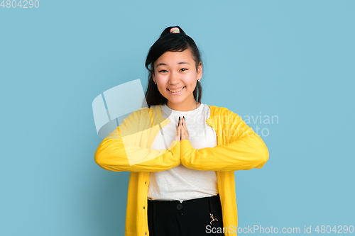 Image of Asian teenager\'s portrait isolated on blue studio background
