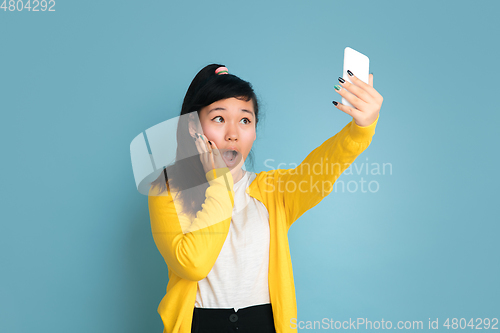 Image of Asian teenager\'s portrait isolated on blue studio background