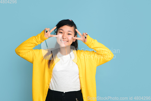 Image of Asian teenager\'s portrait isolated on blue studio background